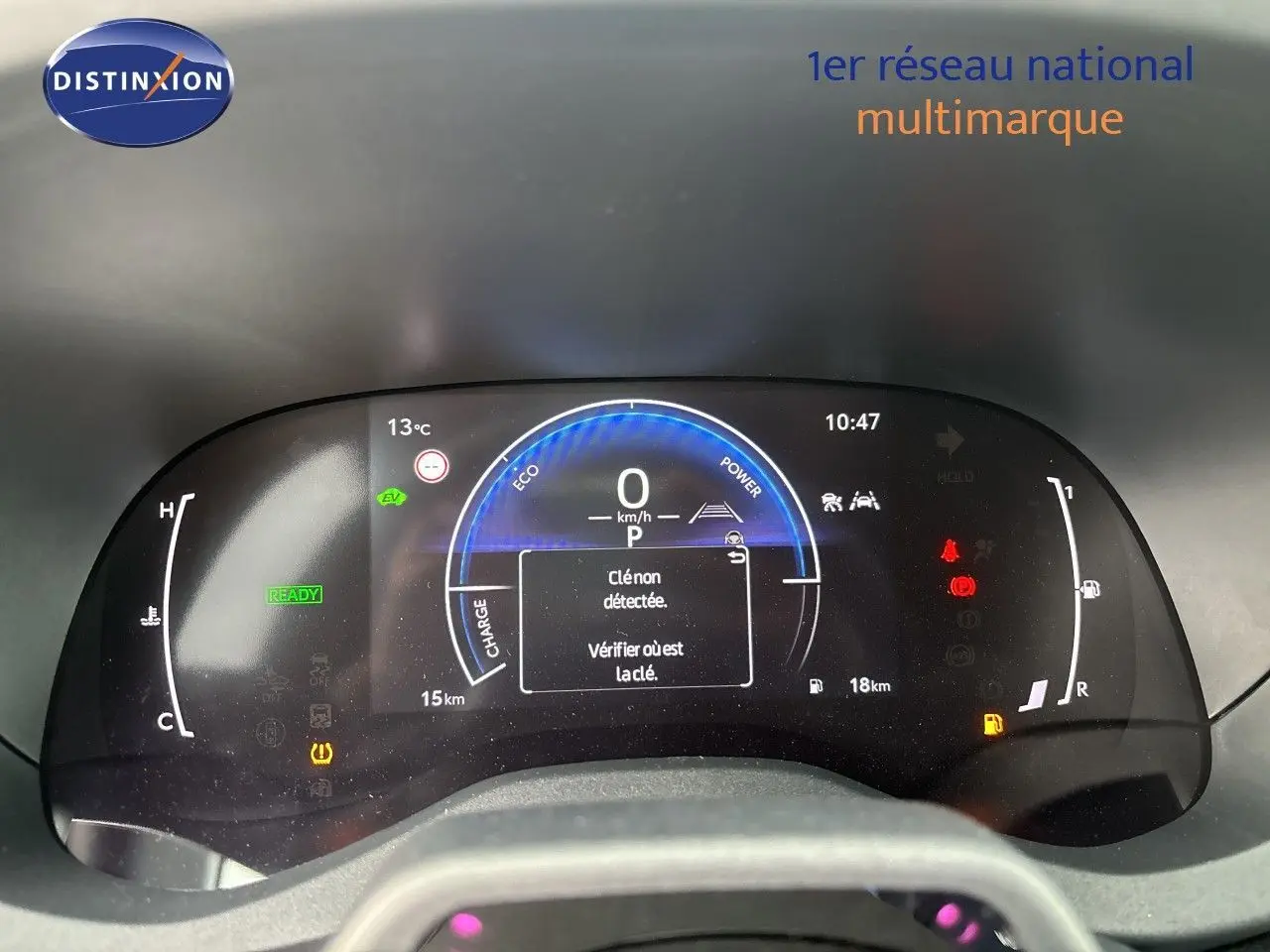 Tableau de bord numérique de Toyota Yaris Cross hybride, affichant la vitesse à 0 km/h et alertes actives, vue frontale.