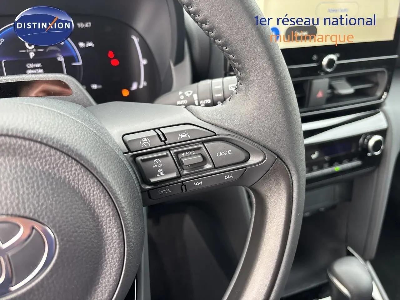 Gros plan sur le volant multifonction et la console centrale de la Toyota Yaris Cross gris atlas, intérieur noir.