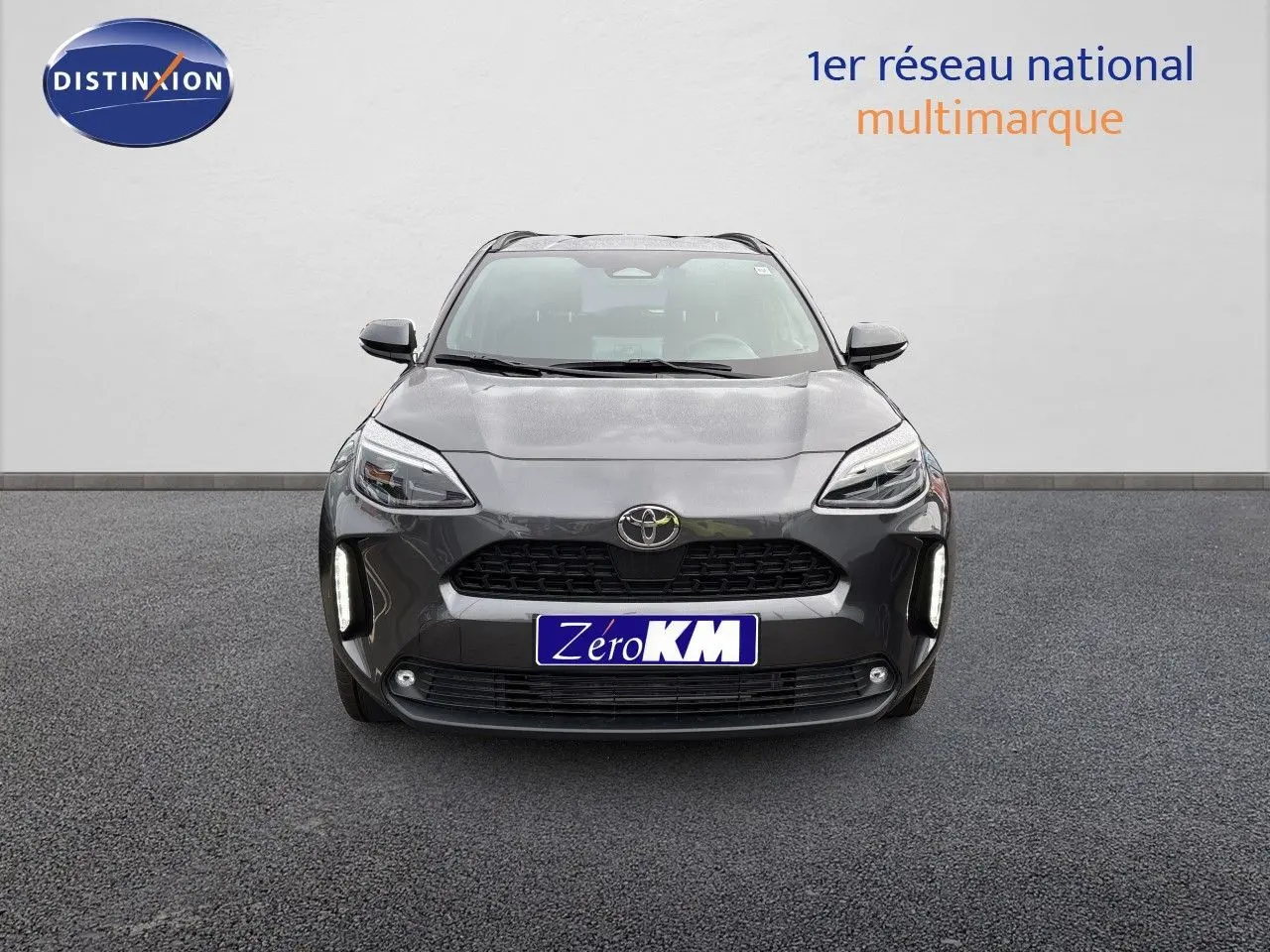 Vue frontale d'une Toyota Yaris Cross gris atlas métal avec feux LED et calandre noire distinctive.