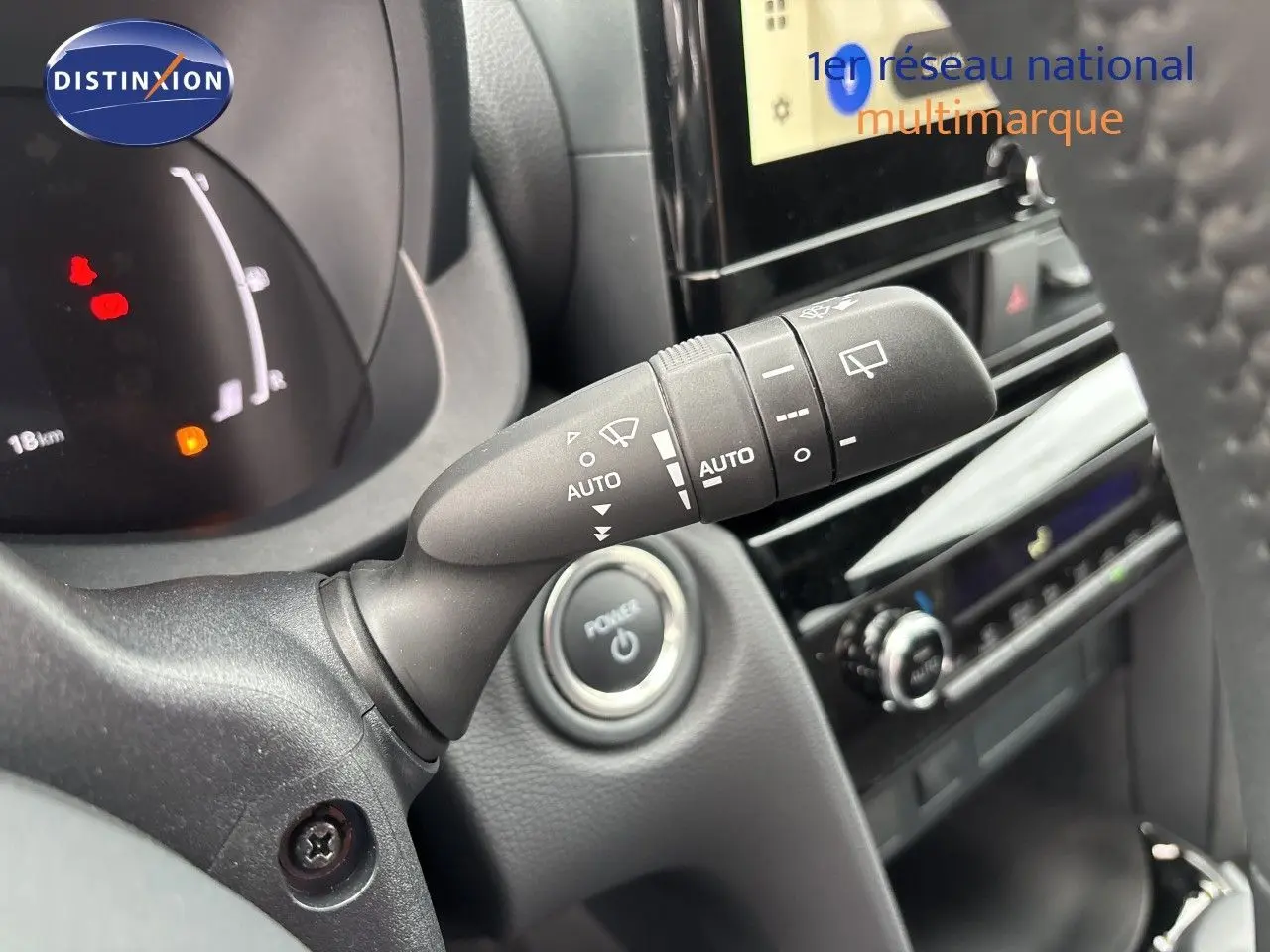 Gros plan intérieur sur la commande d’essuie-glace et le bouton start/stop d’une Toyota Yaris Cross gris atlas.
