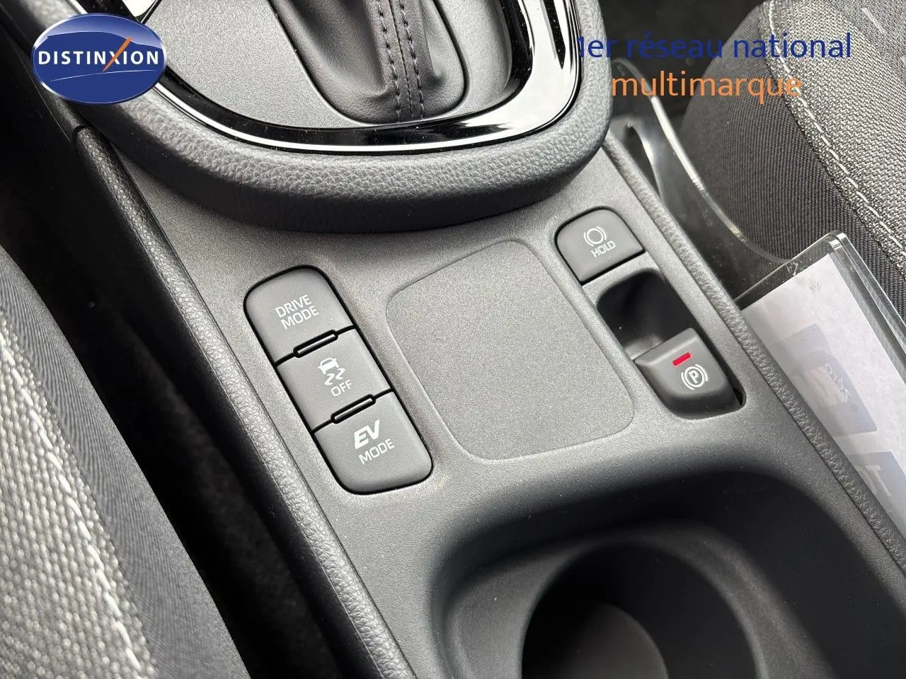 Gros plan sur la console centrale de la Toyota Yaris Cross gris atlas, montrant les boutons Drive Mode, EV Mode et frein à main électrique.