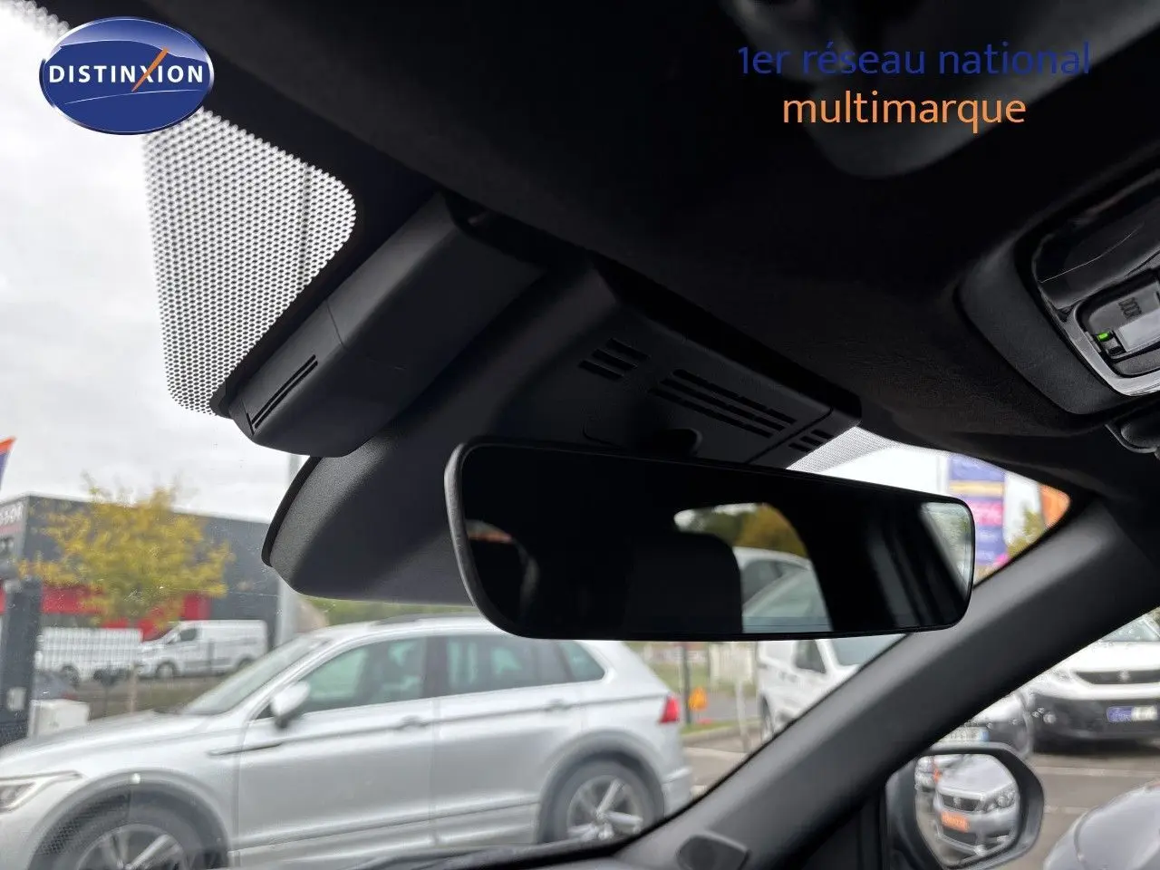 Vue intérieure du rétroviseur central d'une Toyota Yaris Cross gris atlas metal, avec aperçu du pare-brise et extérieur flou.