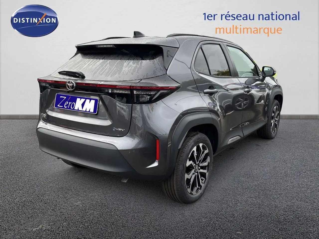 Toyota Yaris Cross gris atlas metal vue 3/4 arrière droit, avec jantes alliage et feux arrière LED distinctifs.