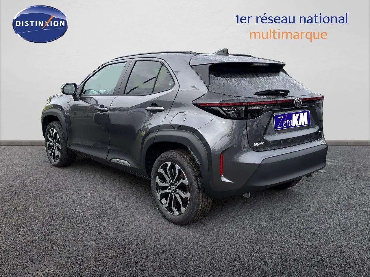Toyota Yaris Cross gris atlas métal vue 3/4 arrière droit, avec jantes alliage et feux arrière LED distinctifs.