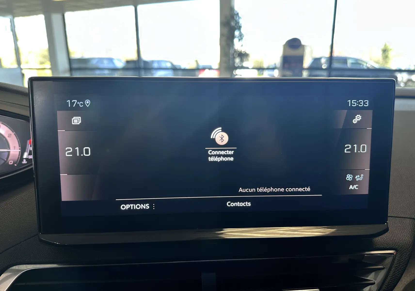 Écran tactile central du Peugeot 3008 blanc nacré 2022 affichant la connexion Bluetooth et la climatisation à 21°C.