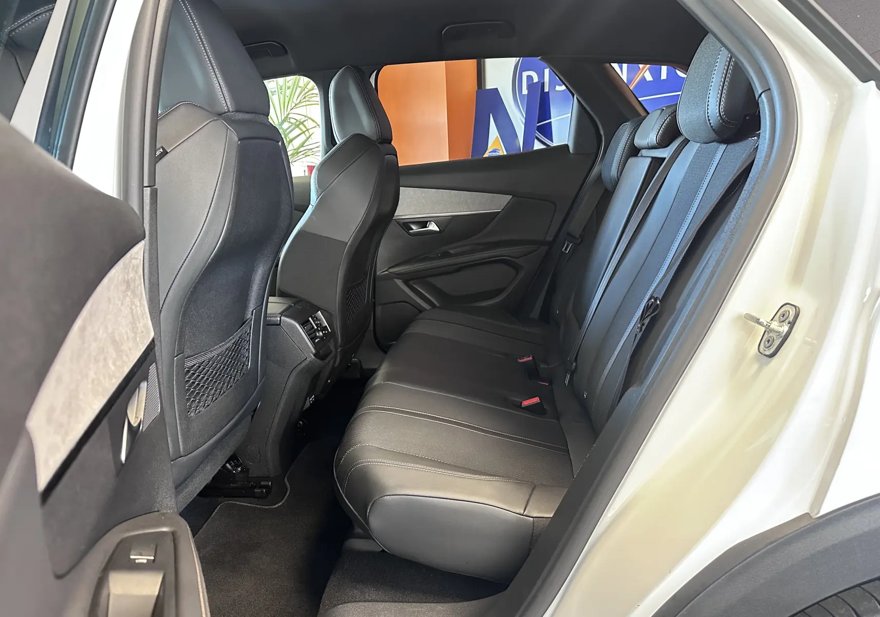 Vue intérieure côté droit sur la banquette arrière en cuir noir du Peugeot 3008 blanc nacré 2022.