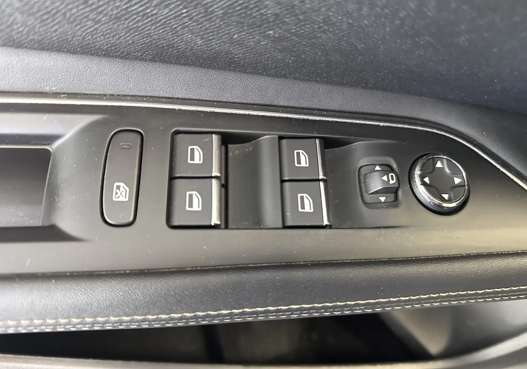 Gros plan sur les commandes de lève-vitres et réglage des rétroviseurs côté conducteur du Peugeot 3008 blanc nacré 2022.