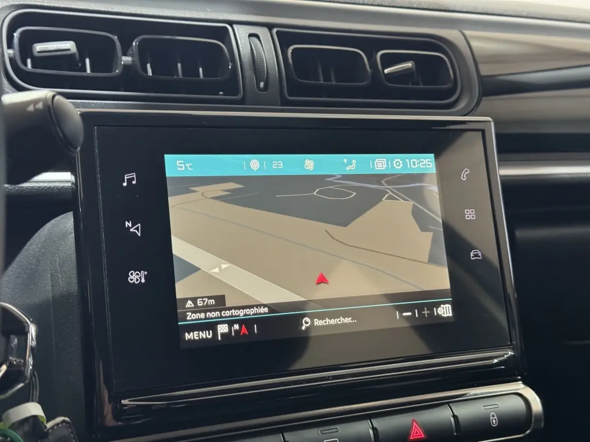 Vue rapprochée de l’écran tactile 7 pouces du système de navigation dans le tableau de bord noir du Citroën C3 bleu.