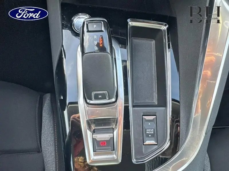 Gros plan sur la console centrale noire avec levier de vitesse automatique et bouton Drive Mode, intérieur Peugeot 5008 blanc.