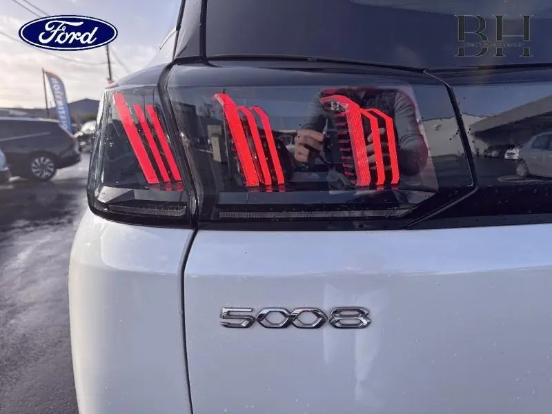 Gros plan sur le feu arrière droit rouge et noir du Peugeot 5008 blanc Banquise, avec le logo 5008 visible.