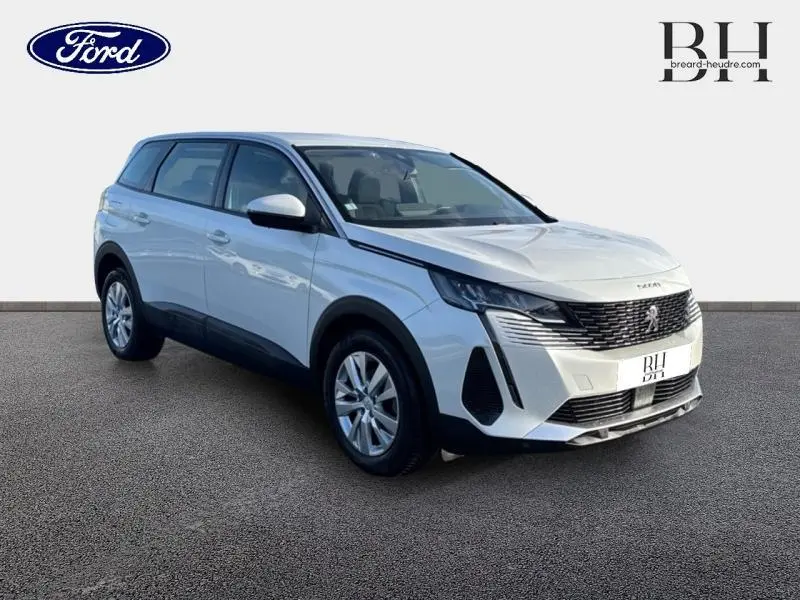 Peugeot 5008 blanc banquise vue 3/4 avant droit, avec calandre noire distinctive et jantes alu.