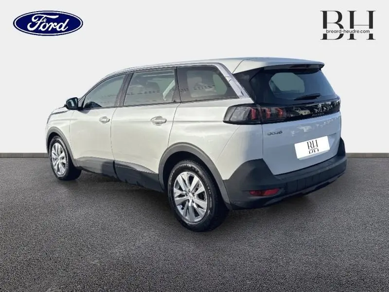 Vue 3/4 arrière droite d’un Peugeot 5008 blanc Banquise avec feux arrière noirs et jantes alu.