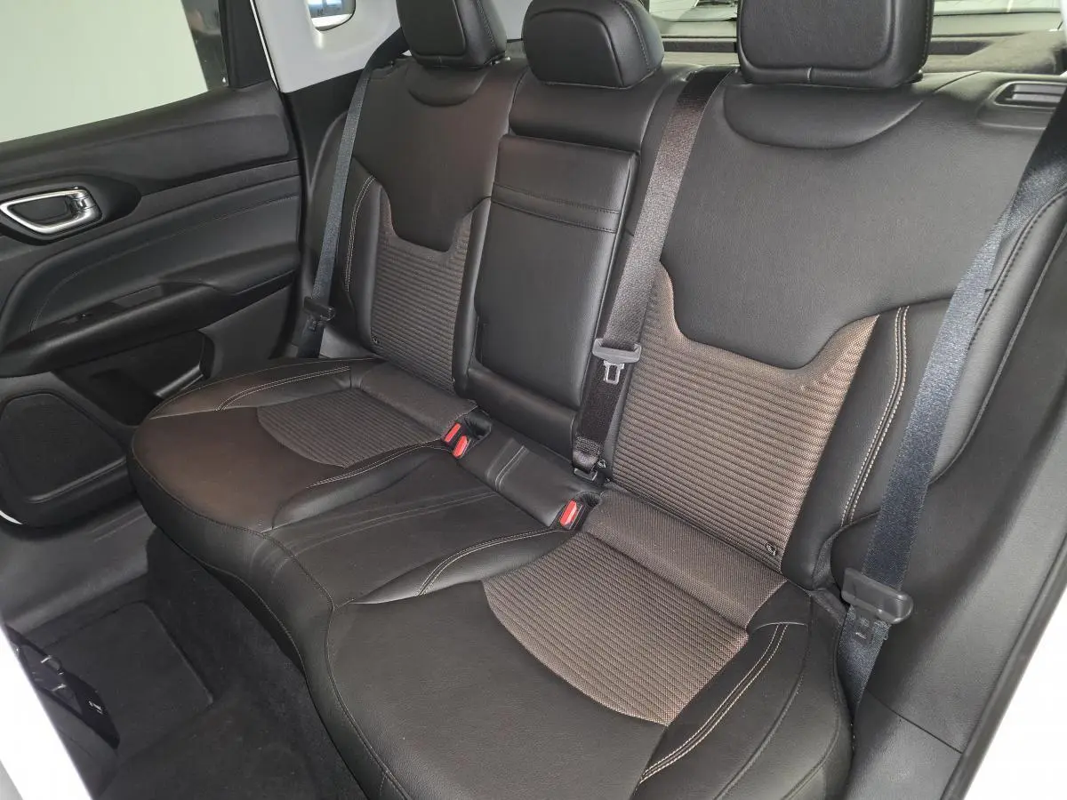 Vue latérale droite de la banquette arrière en sellerie mixte noir et bronze du Jeep Compass 2024 hybride rechargeable.