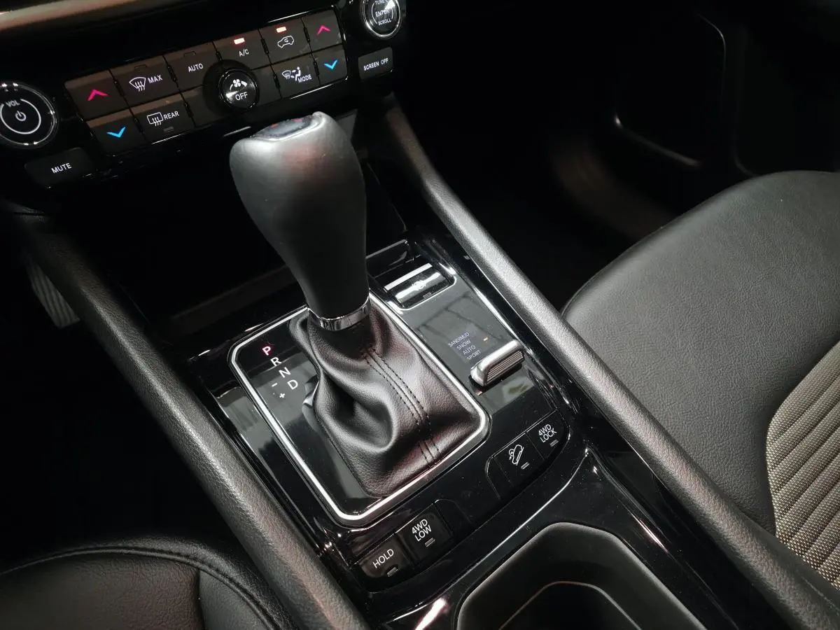 Gros plan sur la console centrale noire avec levier de vitesse et commandes 4WD du Jeep Compass blanc 2024.