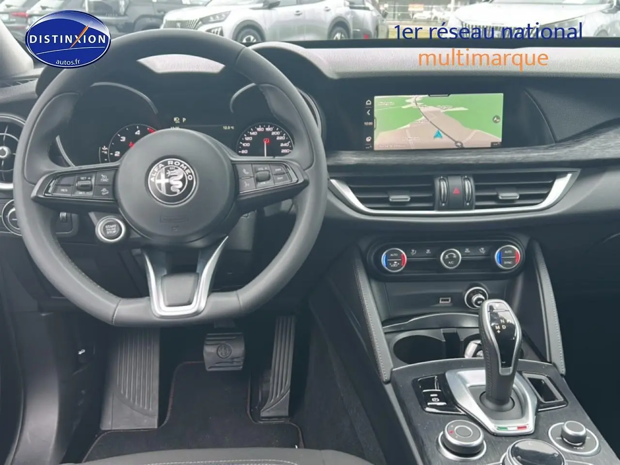 Vue intérieure de l'Alfa Romeo Stelvio 2021, tableau de bord et console centrale avec écran tactile et volant cuir.
