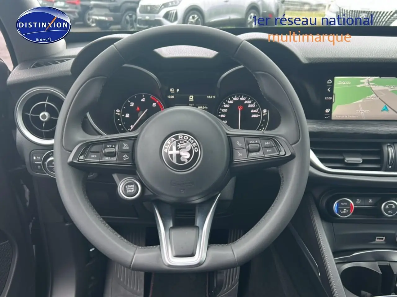Vue frontale du volant cuir multifonction d'Alfa Romeo Stelvio 2.2 diesel 2021 avec tableau de bord et écran GPS.