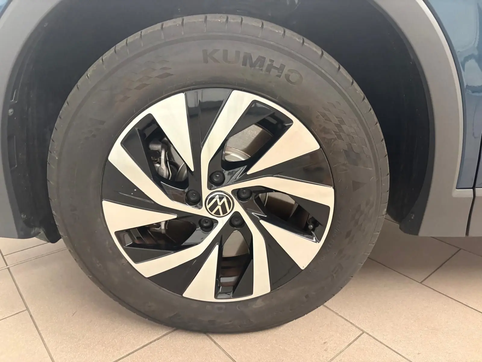 Gros plan sur la roue avant droite du Volkswagen Tiguan 1.5 eHybrid Nightshade Blue avec jante alliage bicolore.