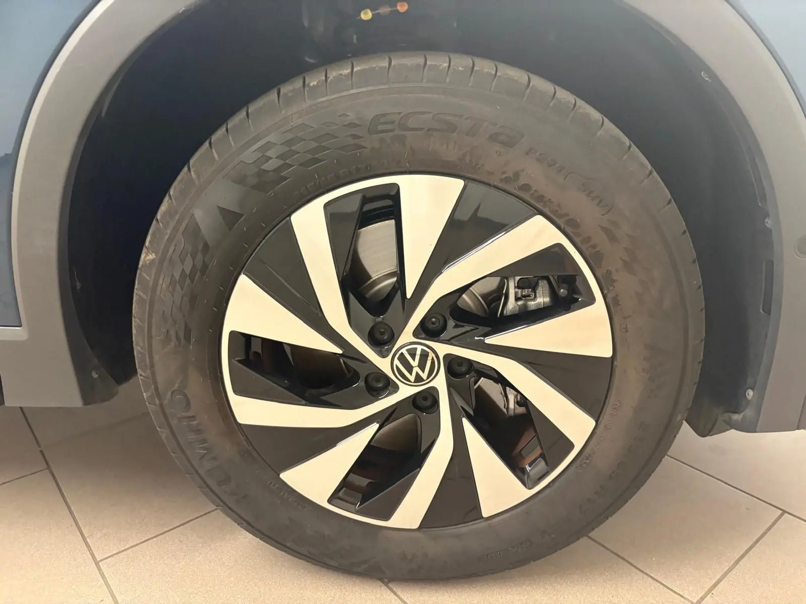 Gros plan sur la roue avant droite du Volkswagen Tiguan 2025 Nightshade Blue, jante alliage bicolore distinctive.