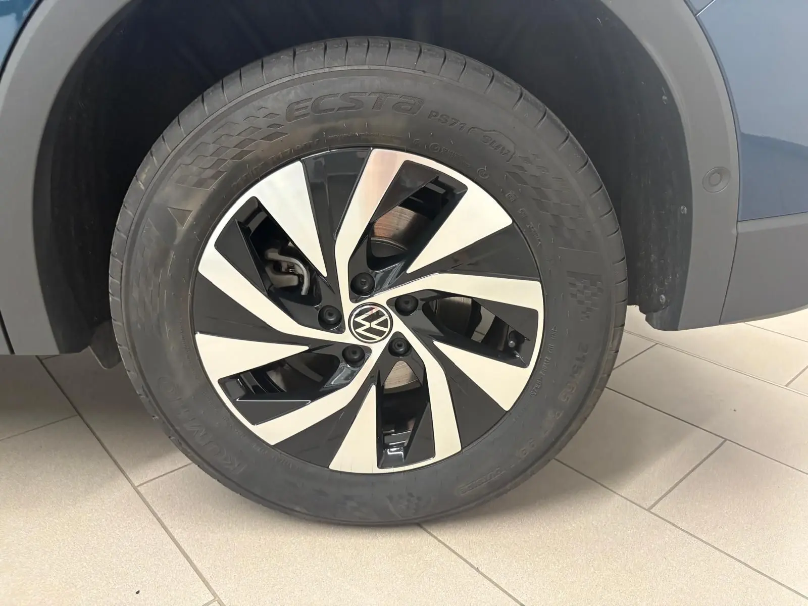 Gros plan sur la roue avant droite du Volkswagen Tiguan 2025 Nightshade Blue avec jante alliage bicolore distinctive.