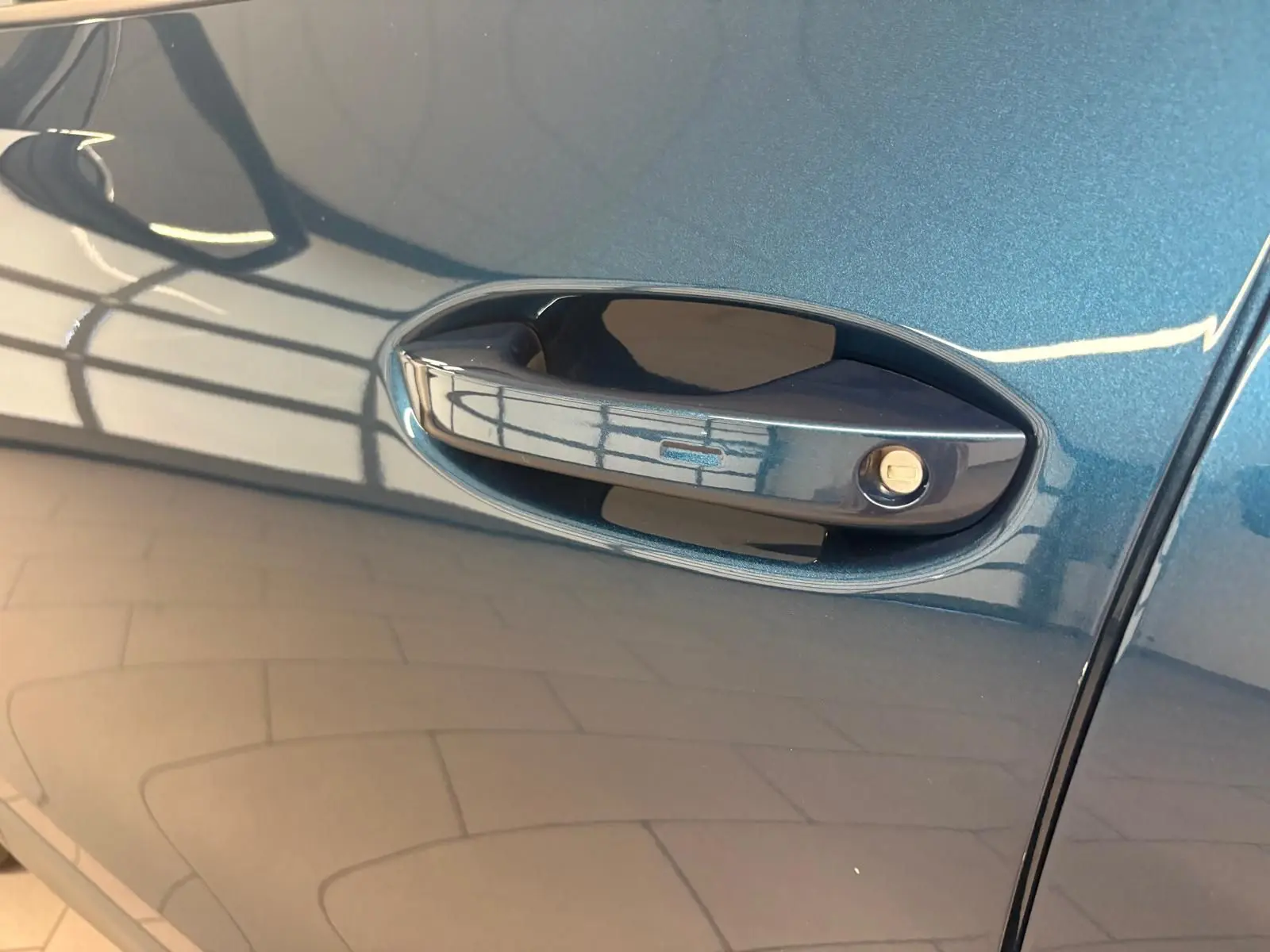 Poignée de porte côté gauche du Volkswagen Tiguan 1.5 eHybrid en peinture métallisée Nightshade Blue.