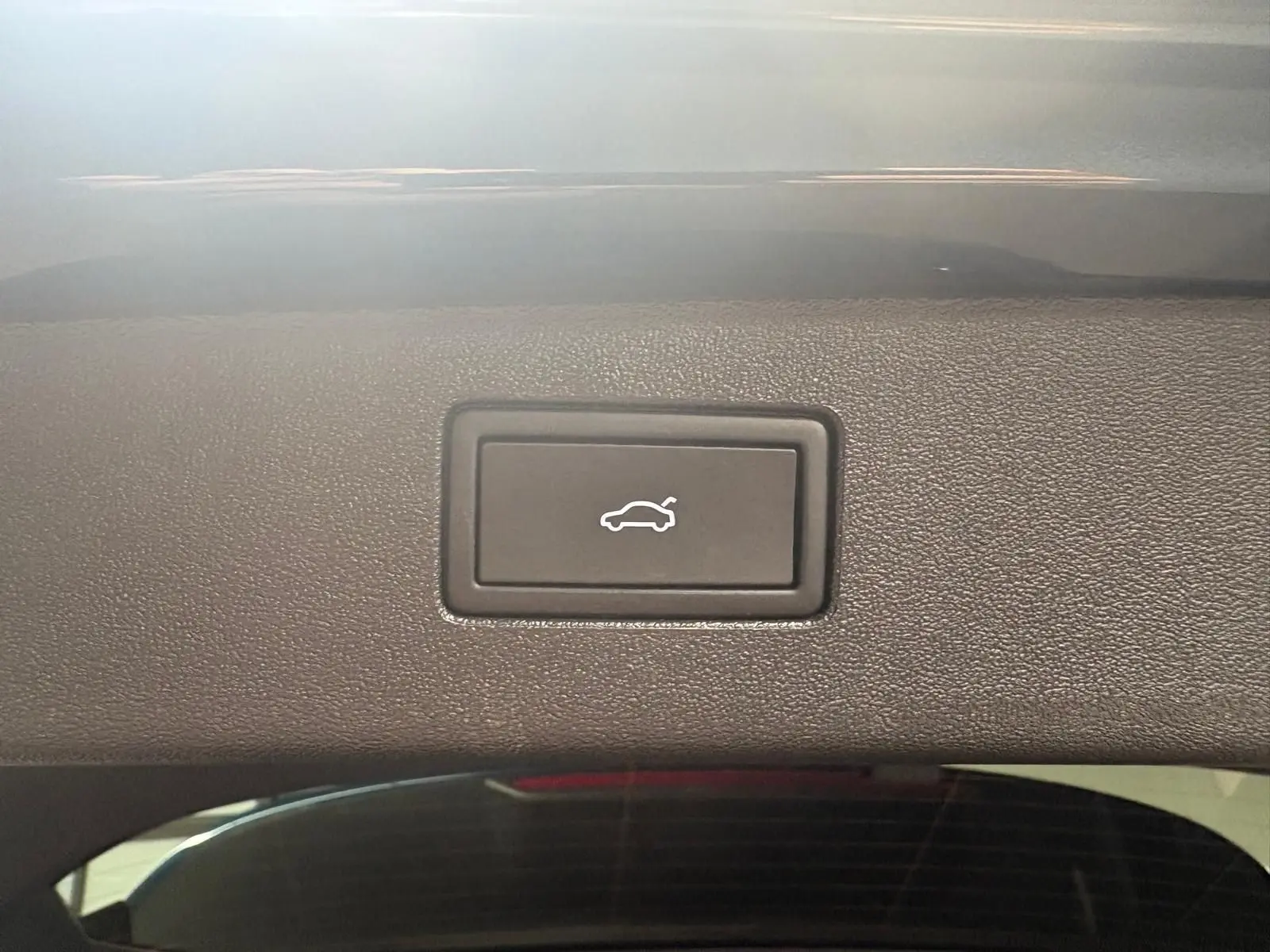 Bouton d'ouverture électrique du coffre sur le hayon intérieur d'un Volkswagen Tiguan 2025 Nightshade Blue.