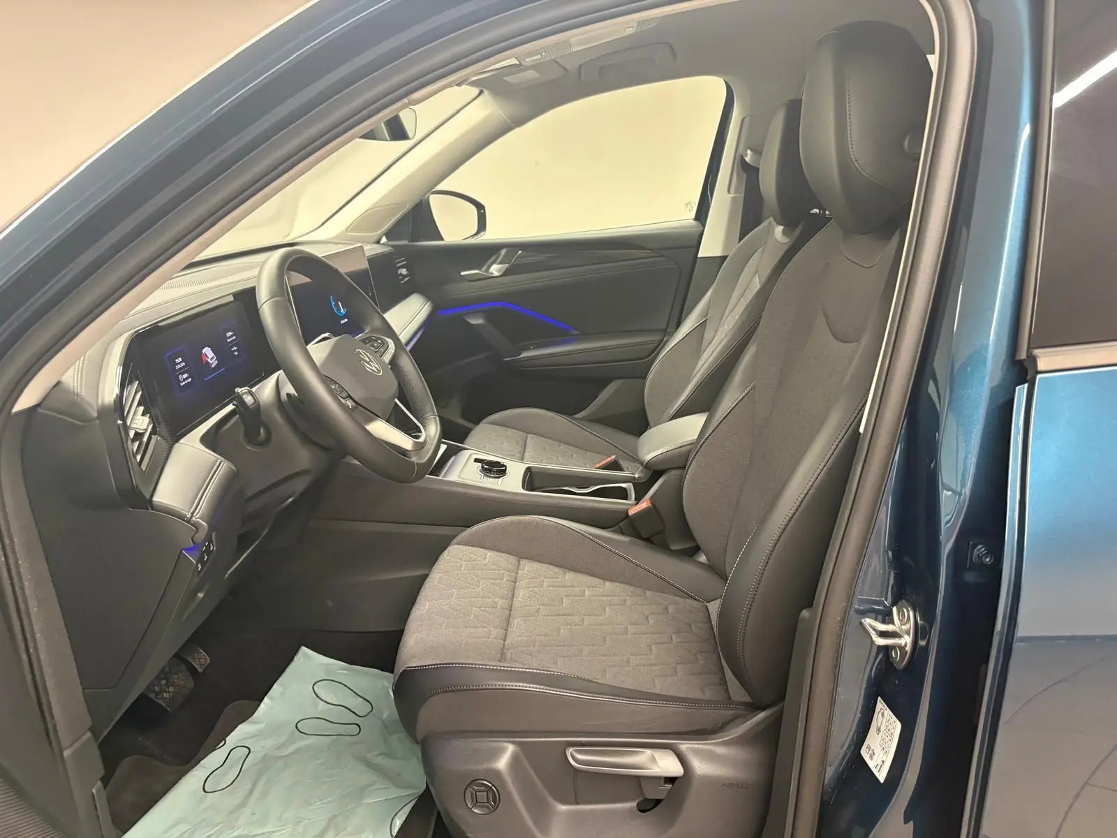 Vue intérieure côté conducteur du Volkswagen Tiguan 2025 en Nightshade Blue, sièges et volant chauffants visibles.