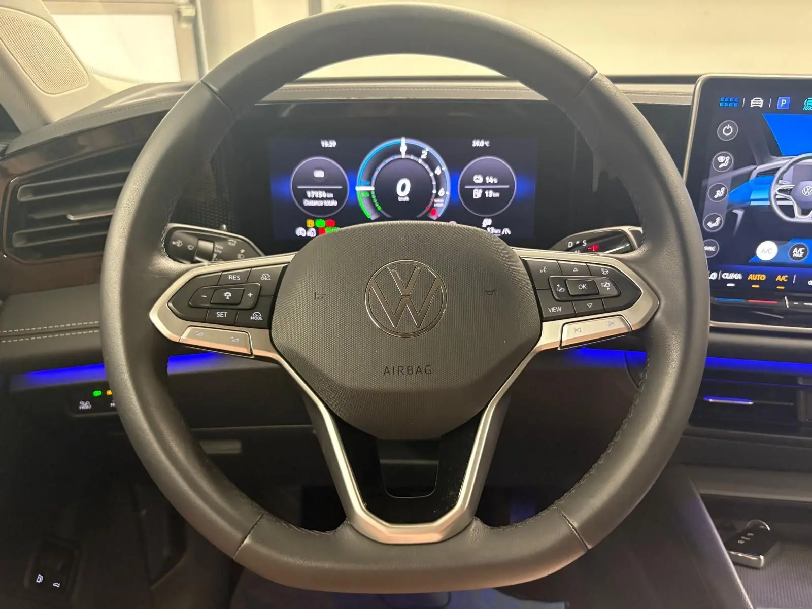 Vue rapprochée du volant noir chauffant du Volkswagen Tiguan 1.5 eHybrid 2025 avec tableau de bord numérique et écran tactile.