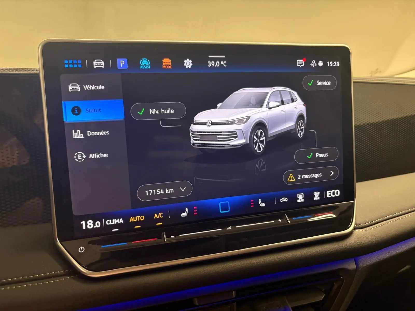 Écran tactile central affichant le statut du Volkswagen Tiguan 2025 en vue 3/4 avant, interface moderne et claire.