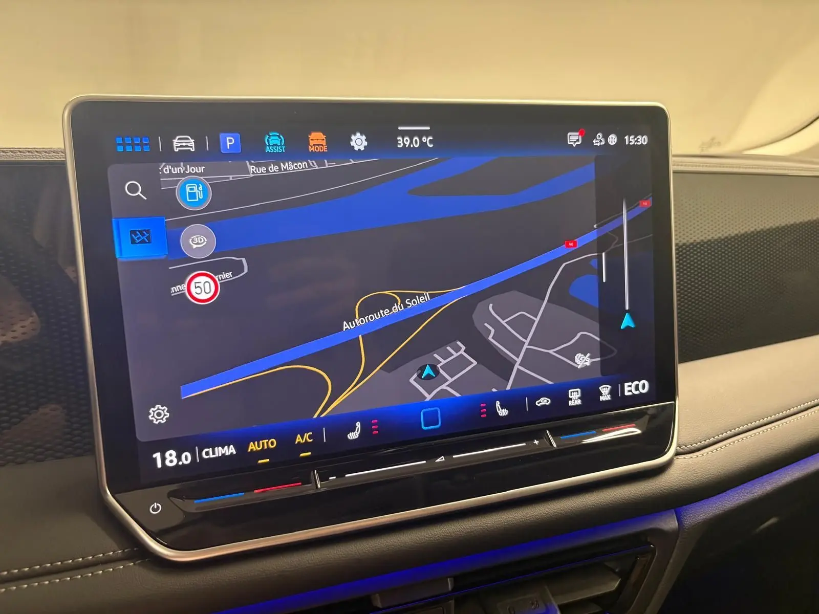 Écran tactile central du Volkswagen Tiguan 2025 affichant la navigation, avec éclairage d'ambiance bleu et tableau de bord beige.