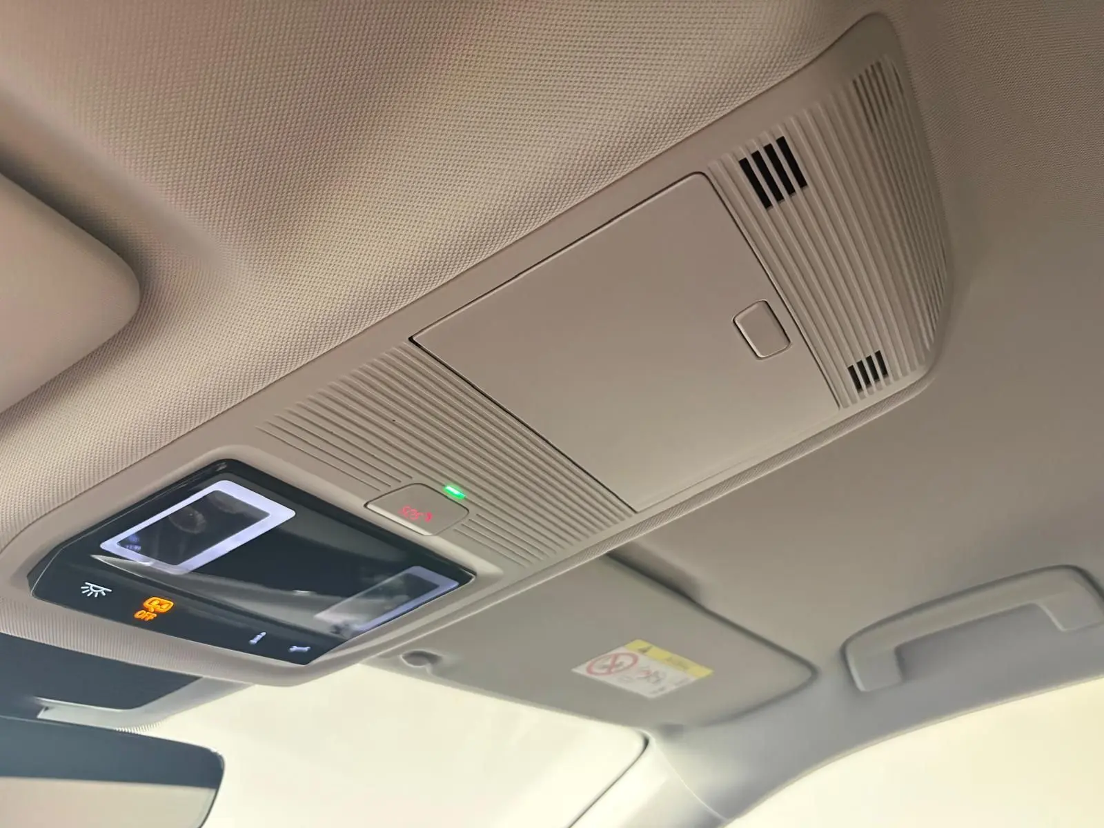 Plafonnier intérieur avec commandes d’éclairage et micro, vue en légère contre-plongée dans un Volkswagen Tiguan 2025.