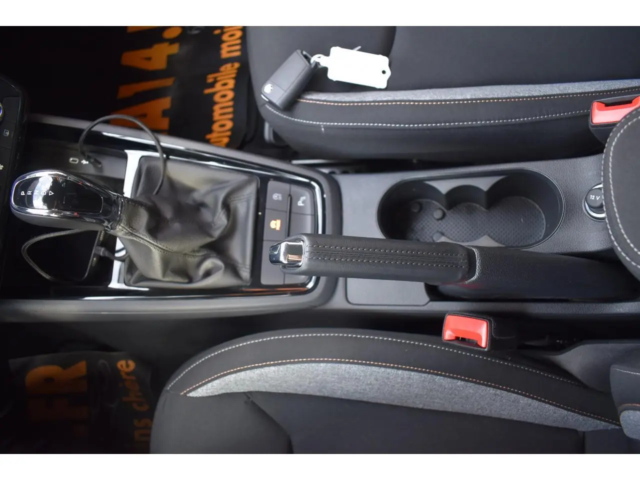 Vue plongeante sur la console centrale noire de la Skoda Scala avec levier de vitesse automatique et frein à main manuel.