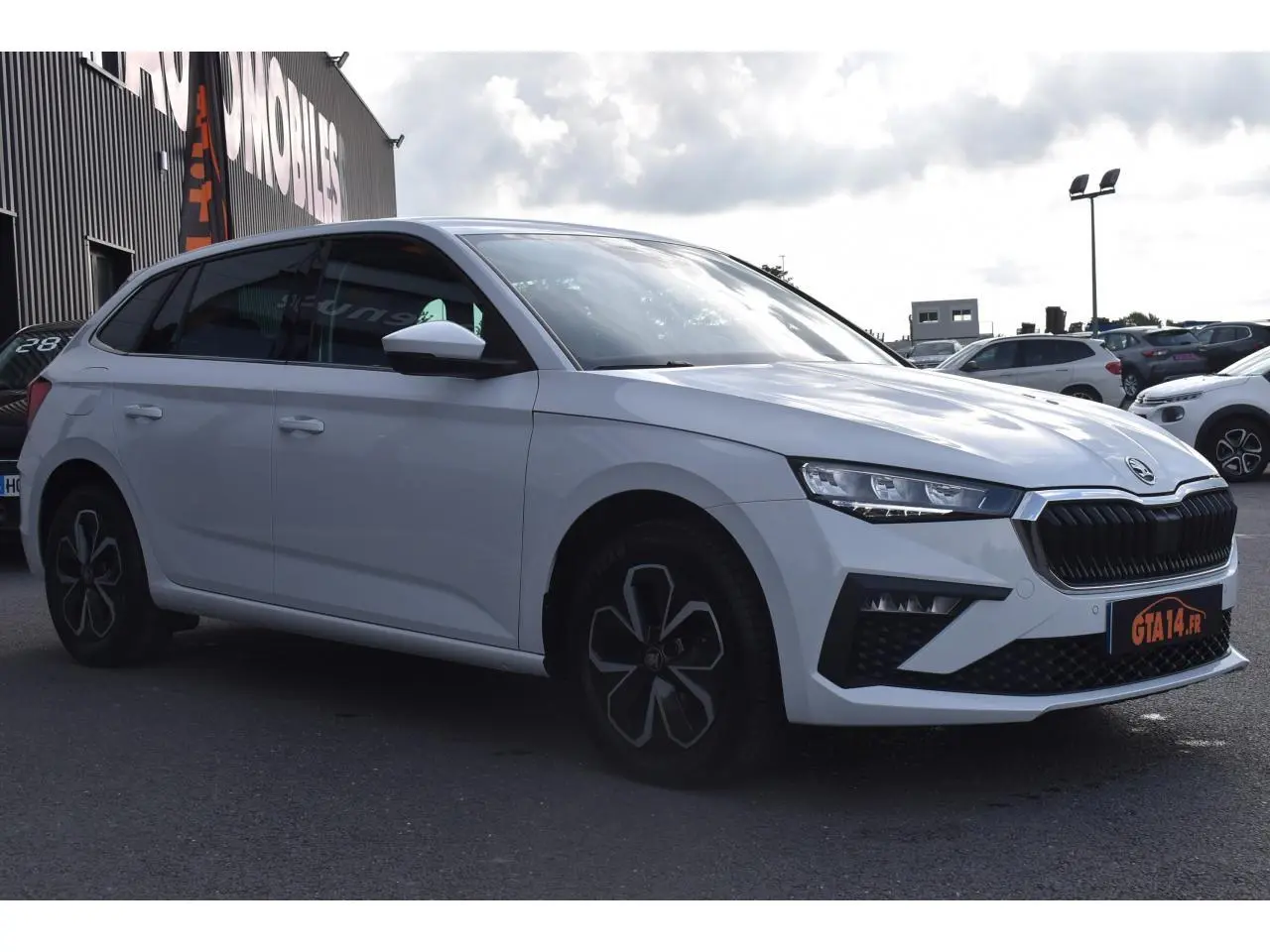 Vue 3/4 avant gauche d'une Skoda Scala blanc glacier avec jantes alliage et calandre noire distinctive.