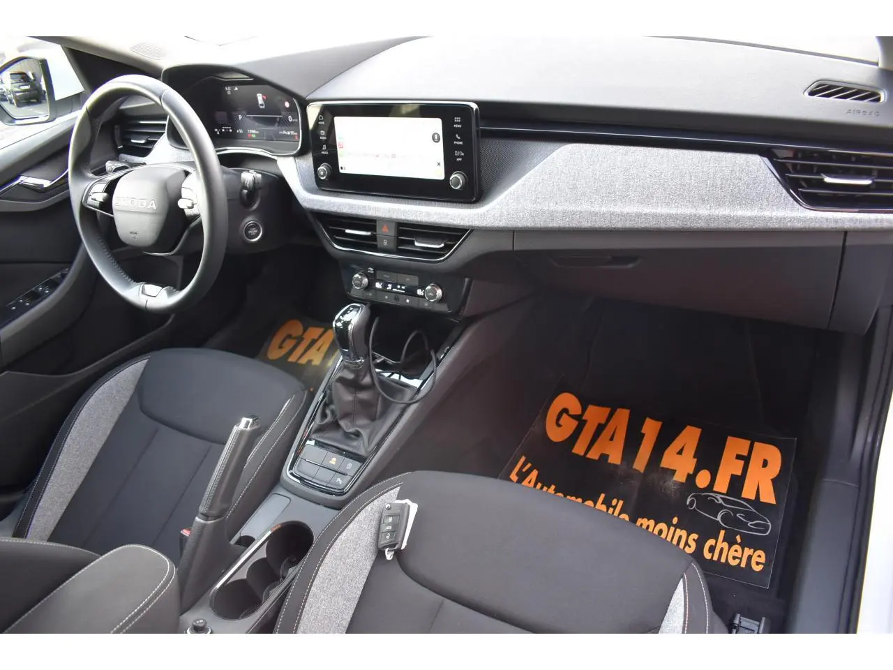 Intérieur de la Skoda Scala blanc glacier vu côté conducteur, avec tableau de bord digital et écran tactile central.