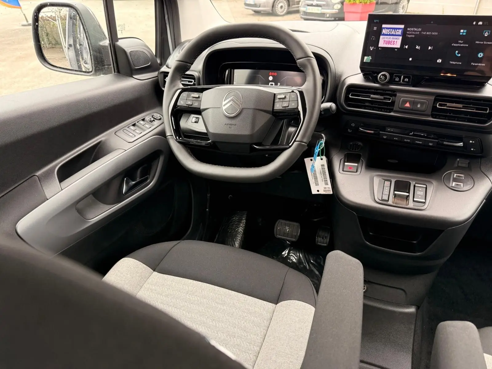 Vue intérieure côté conducteur du Citroën Berlingo 2025, montrant le volant multifonction et l’écran tactile central.