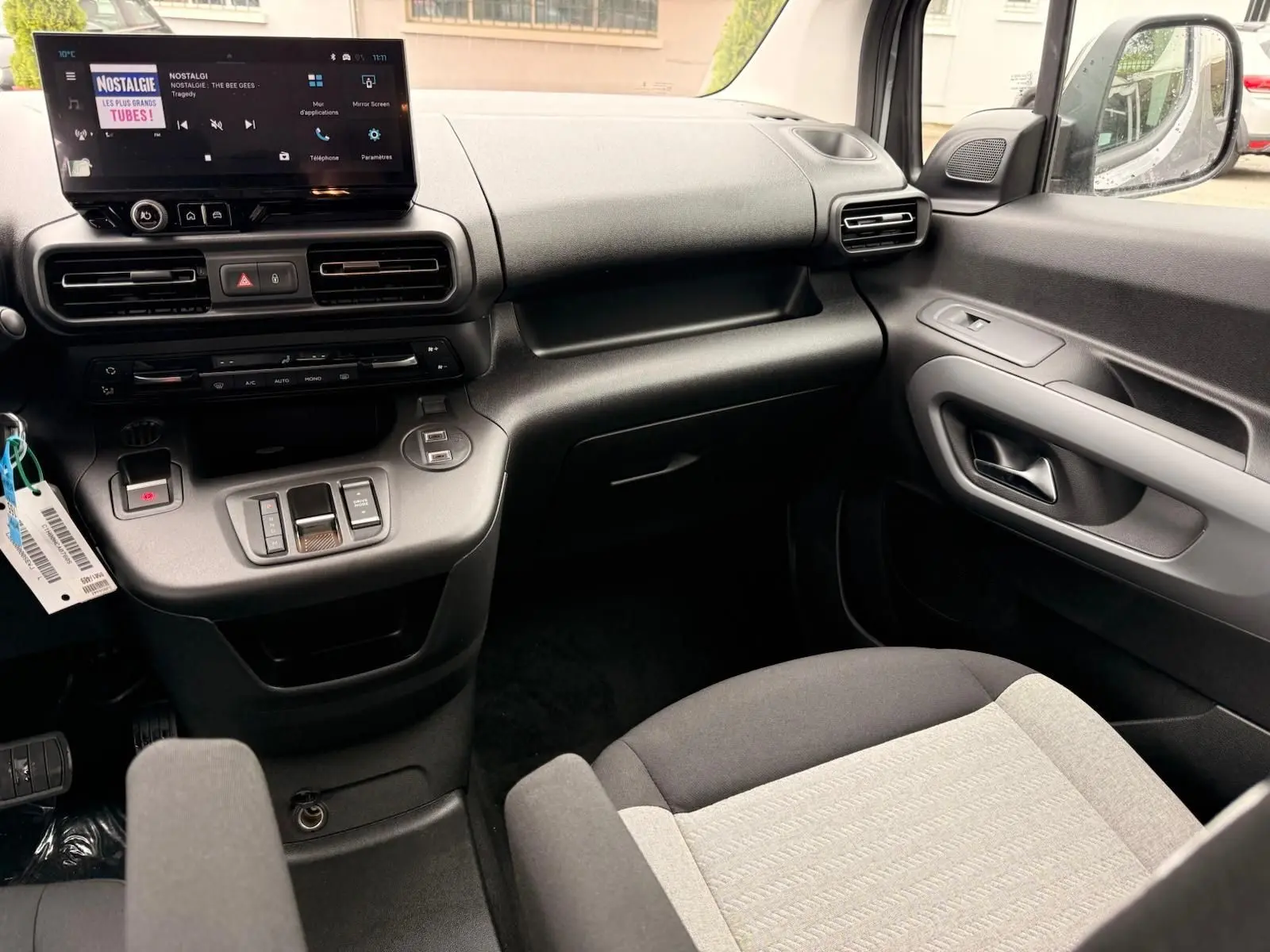 Intérieur côté passager du Citroën Berlingo 2025 gris Artense, avec tableau de bord moderne et écran tactile central.