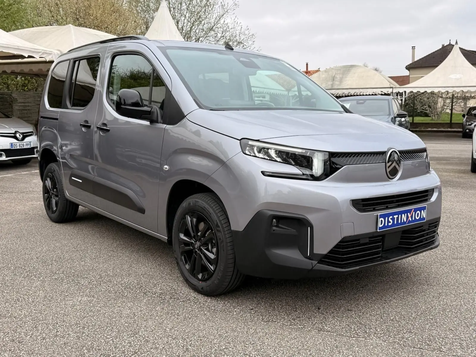 Vue 3/4 avant droit du Citroën Berlingo gris Artense 2025 avec jantes noires et détails noirs contrastants.