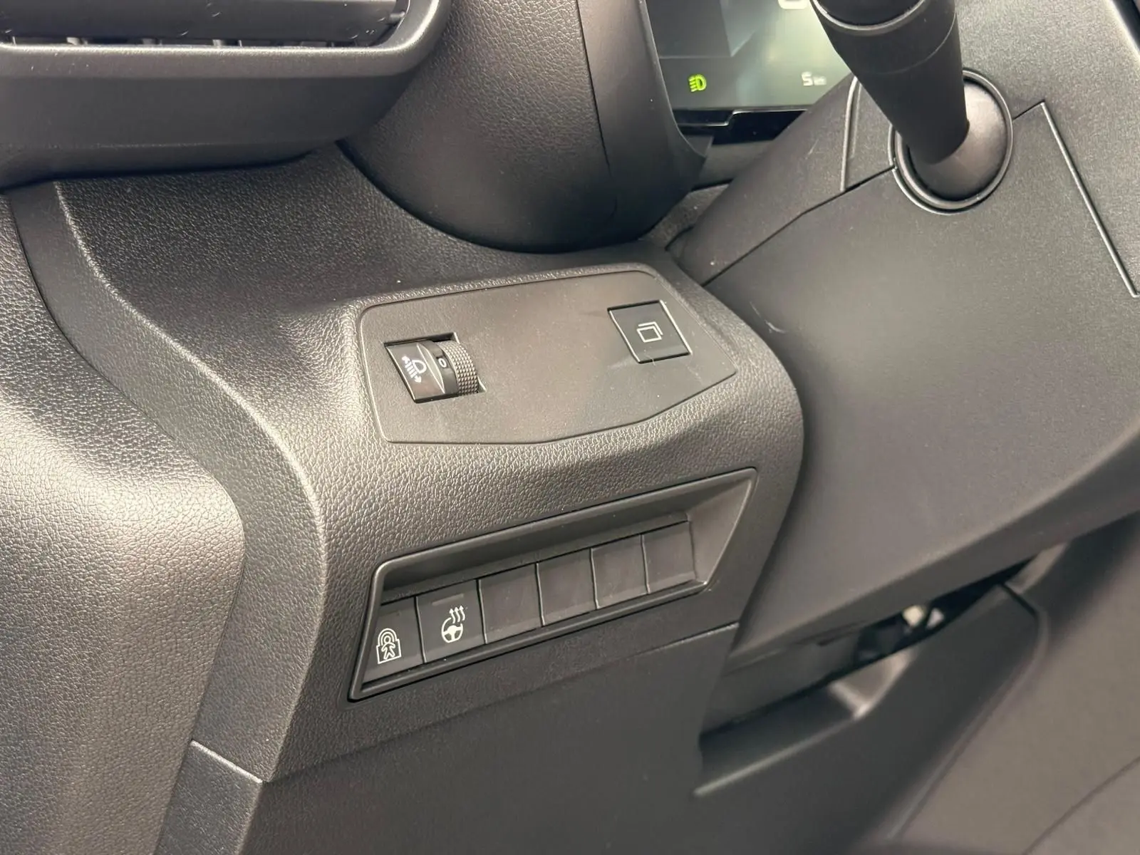 Détail intérieur côté gauche du tableau de bord du Citroën Berlingo gris, avec commandes d’éclairage et chauffage volant.
