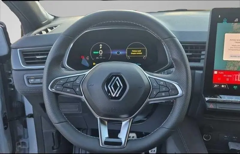 Vue rapprochée du volant noir du Renault Captur E-Tech 2025 avec tableau de bord numérique et écran tactile latéral.