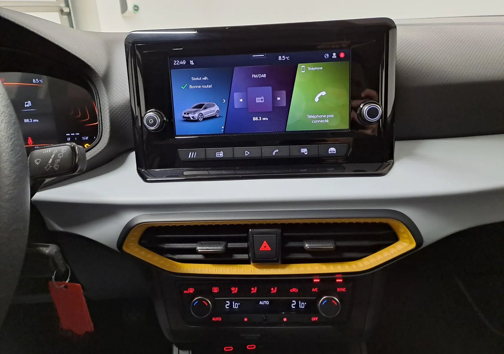 Vue intérieure centrée sur la console centrale de la SEAT IBIZA 2024 avec écran tactile et cadre d’aération jaune.