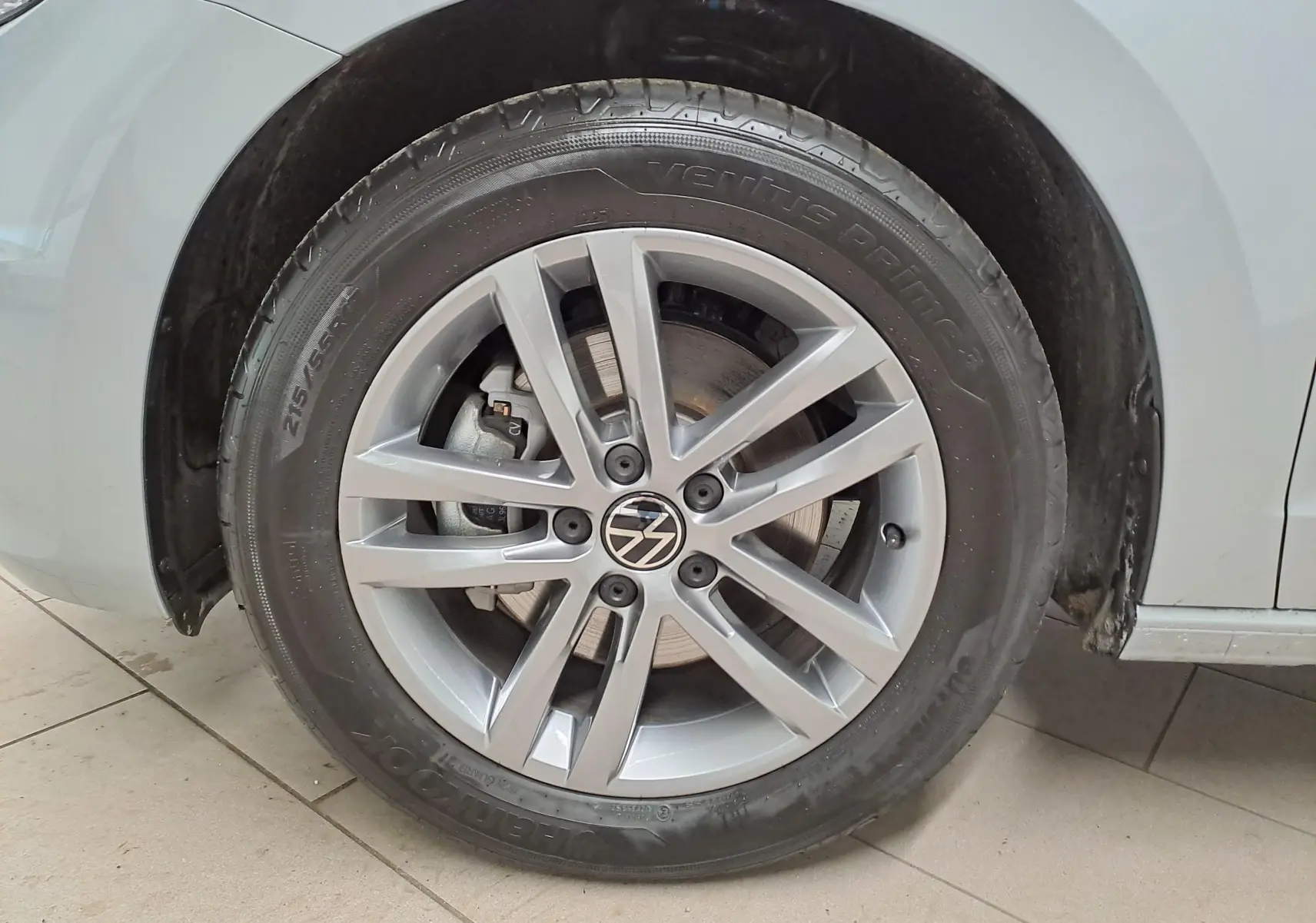 Gros plan sur la roue avant droite argentée du Volkswagen Touran 2025 avec jante alliage et peinture métallisée Argent Dolomite.