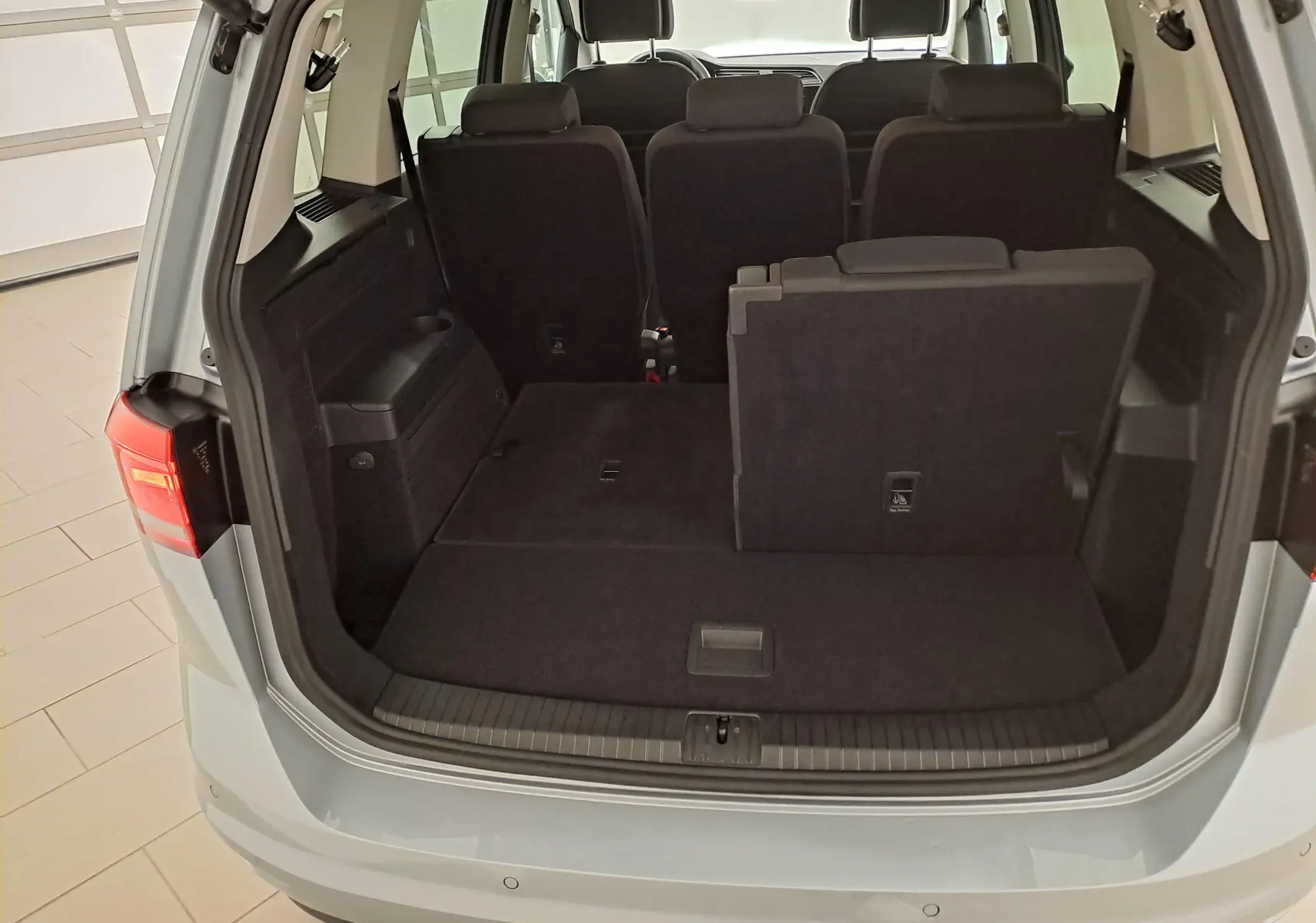 Vue arrière du Volkswagen Touran 2025 argent Dolomite montrant le coffre avec sièges arrière partiellement rabattus.