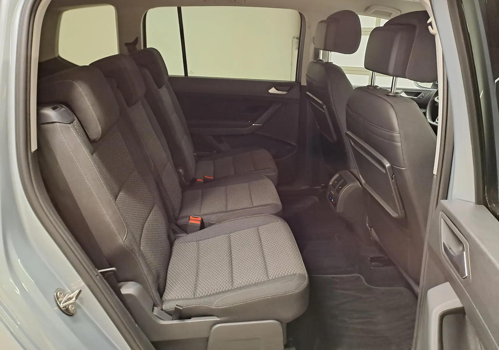 Vue intérieure côté gauche sur la banquette arrière noire du Volkswagen Touran 2025 Argent Dolomite, version 7 places.