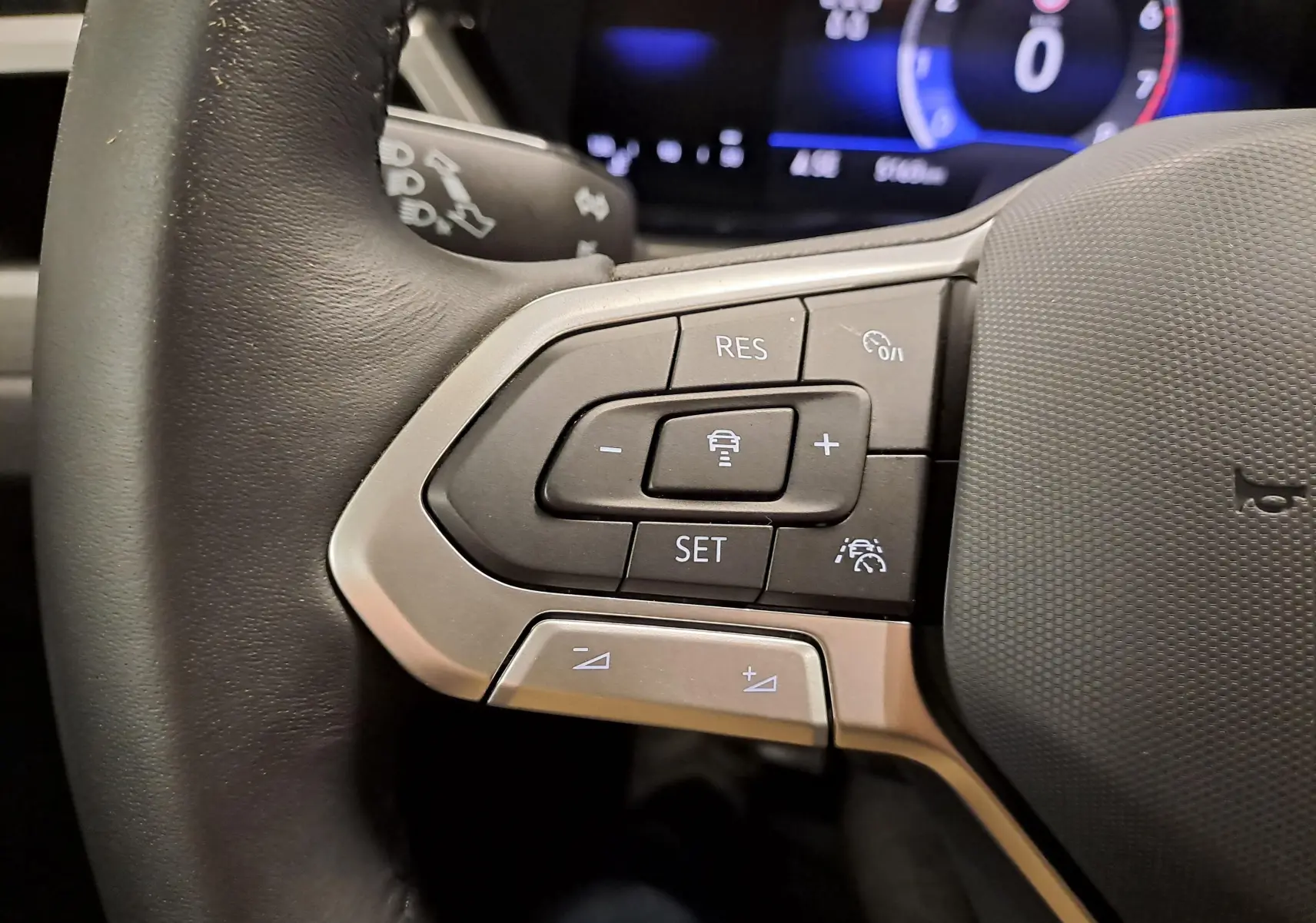 Gros plan sur les commandes au volant du Volkswagen Touran 2025, mettant en valeur les boutons de régulateur de vitesse.