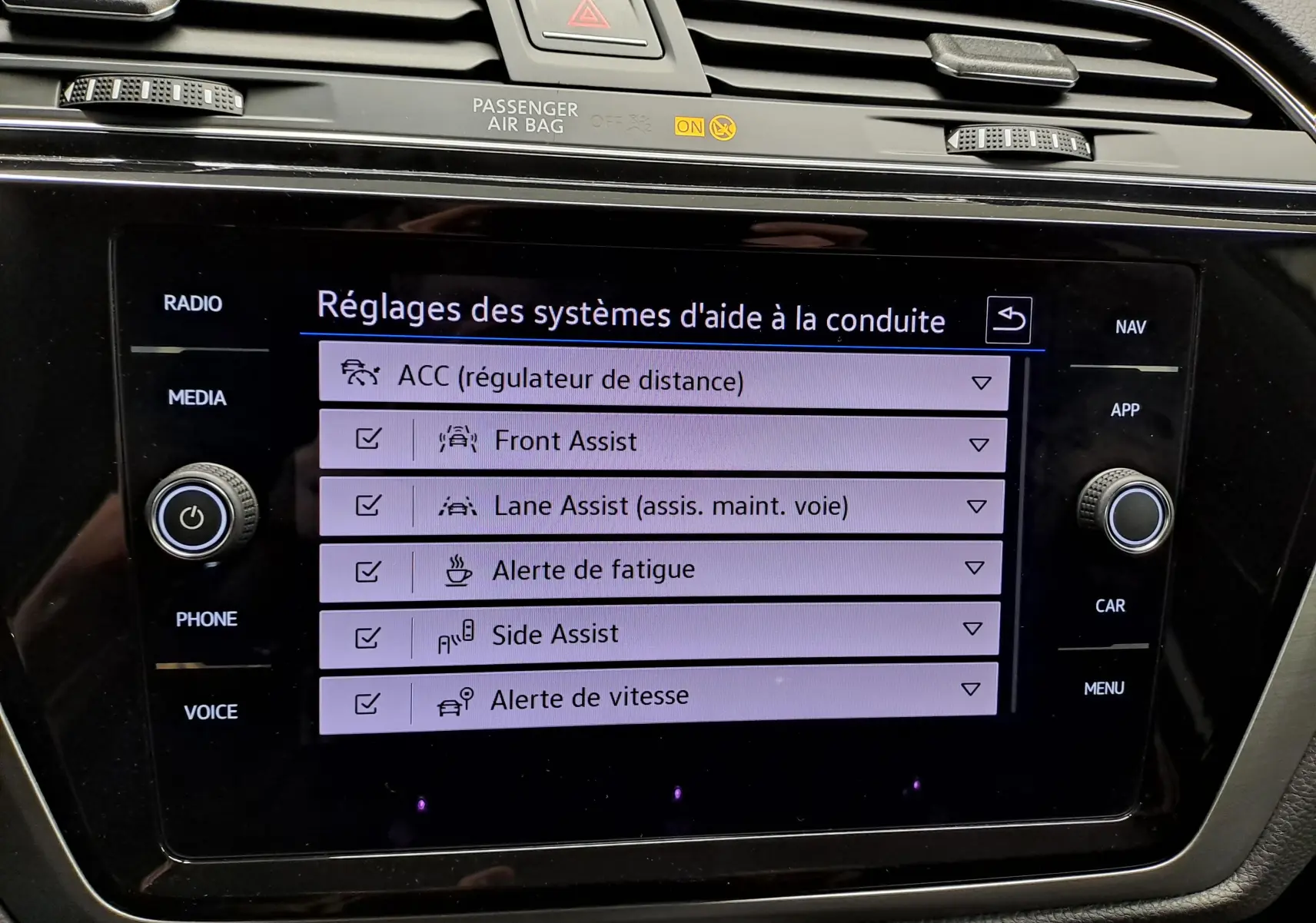 Écran tactile du système d’aide à la conduite du Volkswagen Touran 2025, affichant les réglages des assistances.