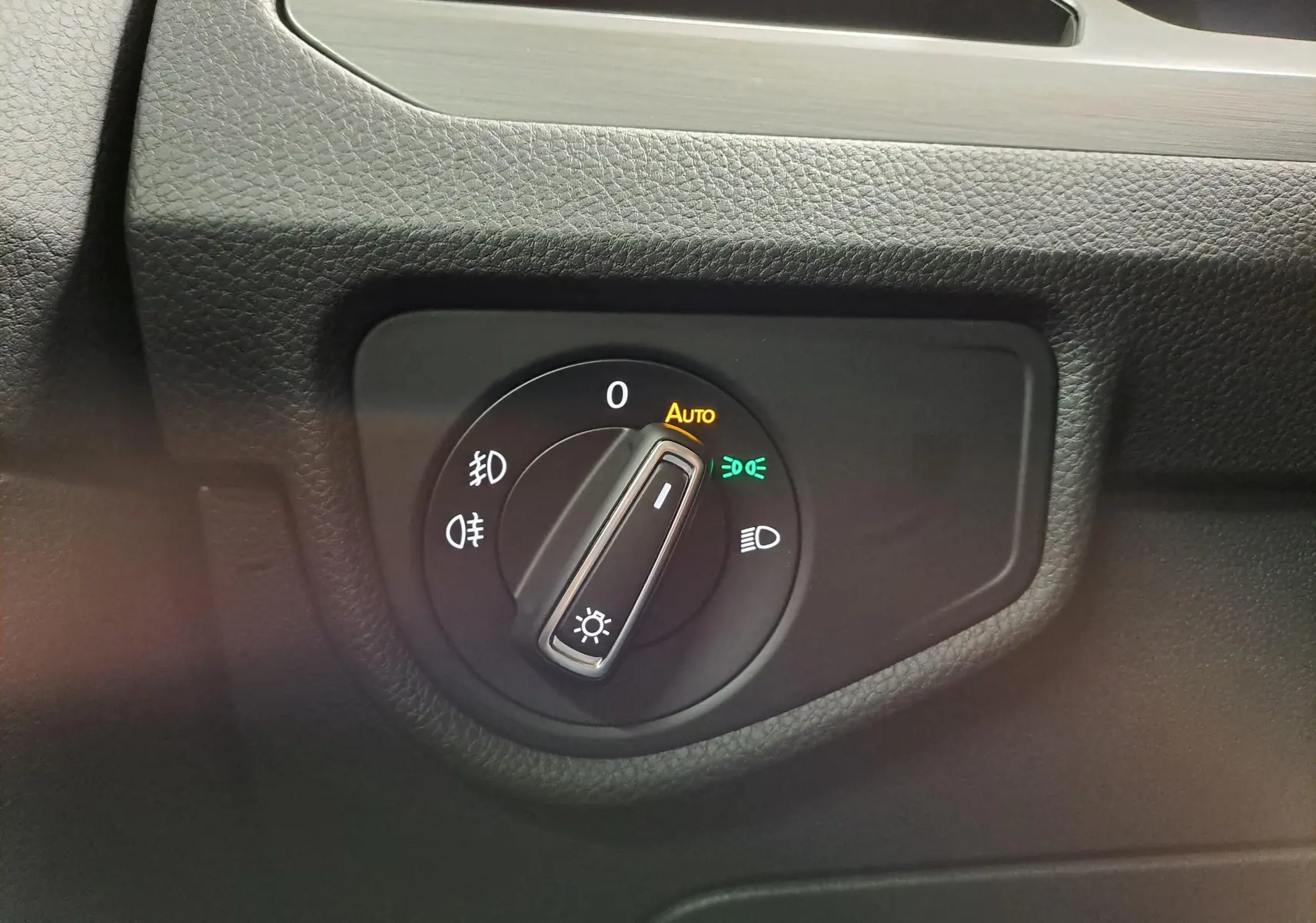 Gros plan sur le bouton de commande des phares du Volkswagen Touran 2025, avec éclairage automatique activé.