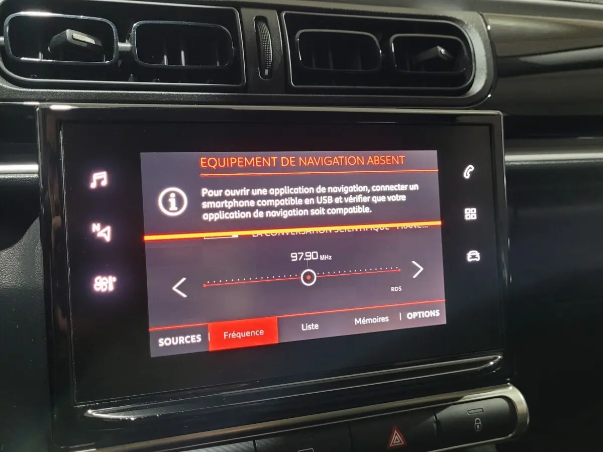 Vue rapprochée de l’écran tactile central de la Citroën C3 beige, affichant un message d’équipement de navigation absent.