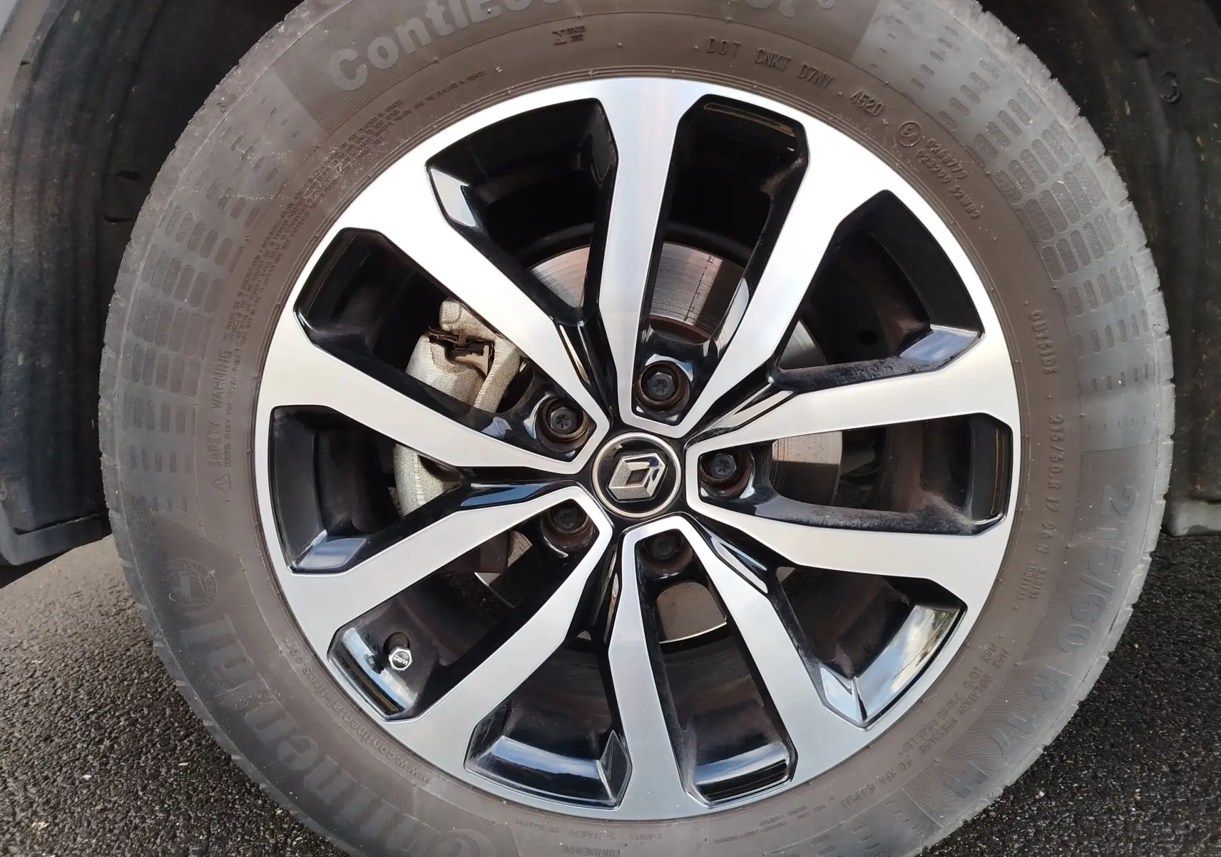 Gros plan sur la jante alliage bicolore noir et argent avec logo Renault au centre du Renault Kadjar gris Titanium.