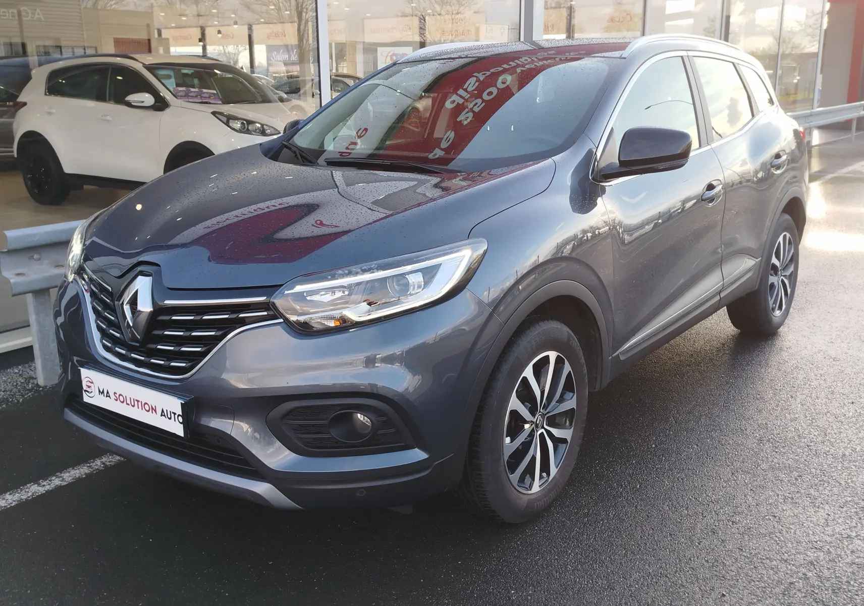 Renault Kadjar gris titanium en vue 3/4 avant droit, avec calandre noire et jantes alliage bi-ton.