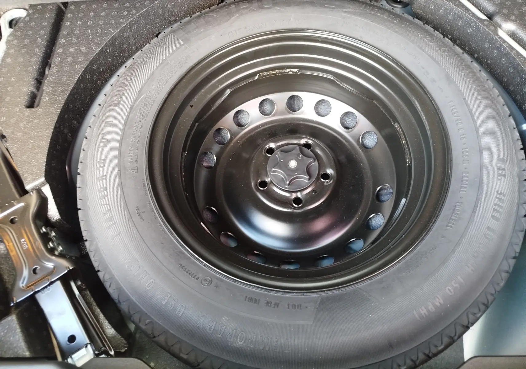 Gros plan sur la roue de secours noire dans le coffre d’un Renault Kadjar gris Titanium 2021.