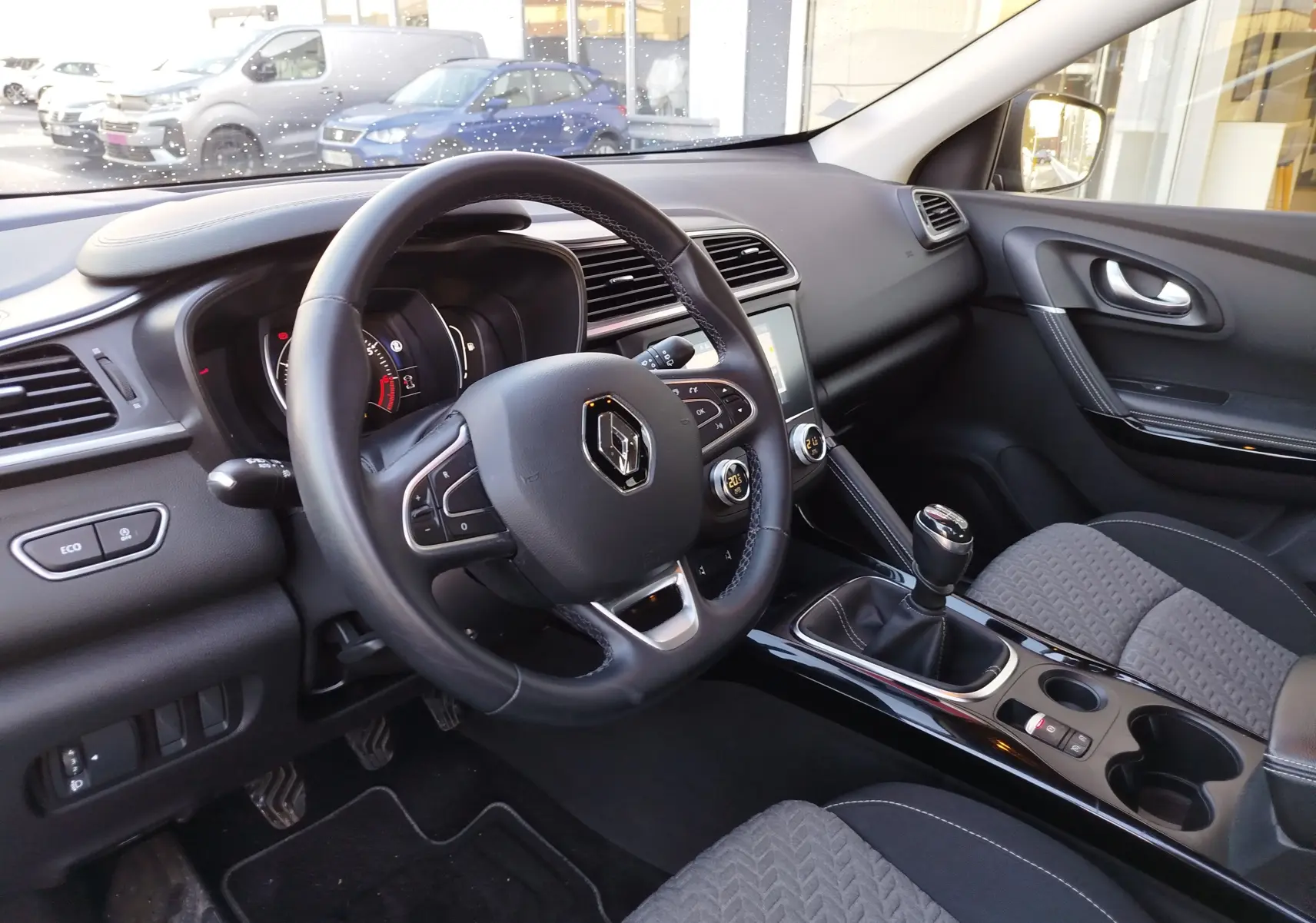 Vue intérieure côté conducteur du Renault Kadjar 1.3 TCe 140ch 2021, volant cuir noir et levier de vitesse manuel.